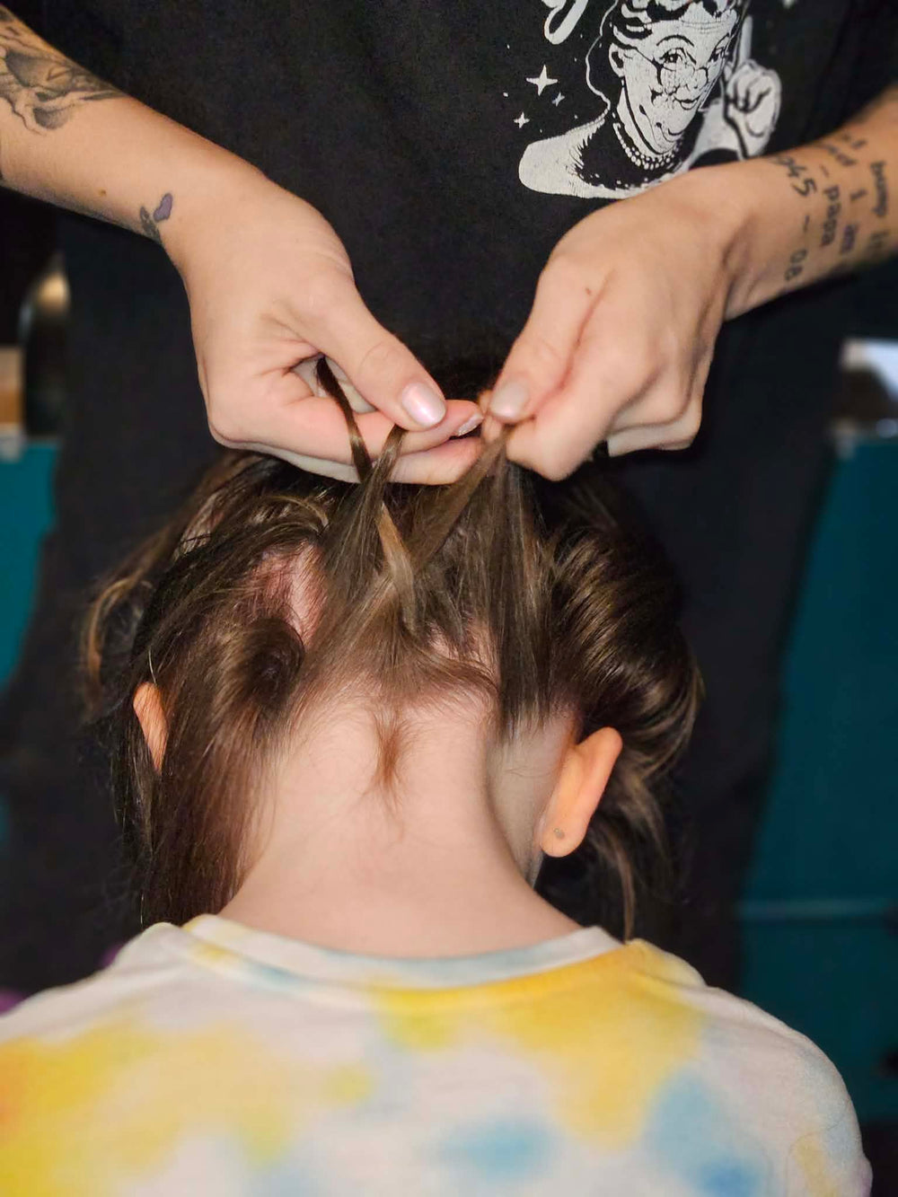 Hands sectioning hair while braiding